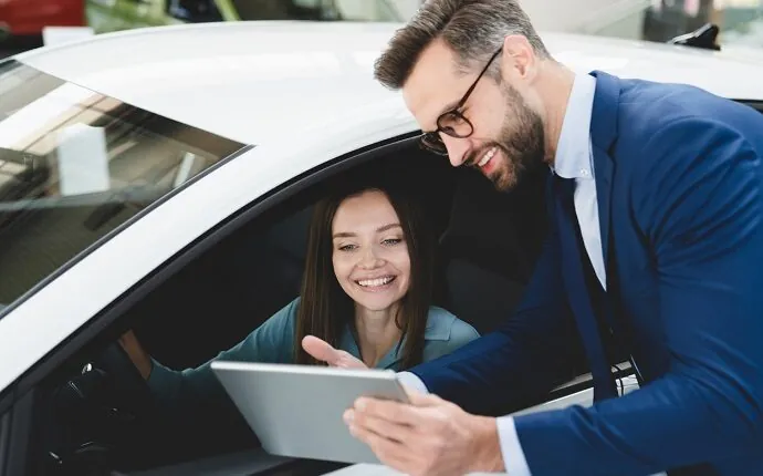 Woman buying a car with salesperson